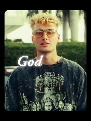 The cover image features a young man with blonde hair, wearing sunglasses and a dark t-shirt. The text overlay on the image says "God". The background is somewhat blurred, appearing to be outdoors with some greenery.
