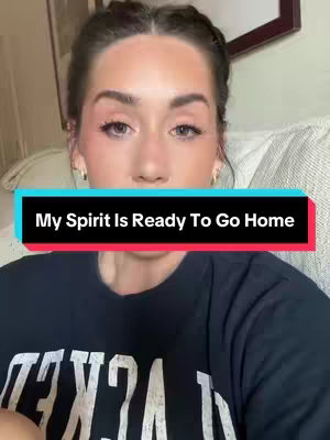 The cover image is a selfie-style shot. The main subject is a light-skinned woman with dark hair pulled back, and appears to be indoors. She is wearing a black t-shirt, and she is centered in the frame, looking directly at the camera. A text overlay in a rectangle at the bottom states "My Spirit Is Ready To Go Home". The background is a blurred neutral tone, suggesting a residential setting.