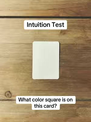 A wooden table serves as the background for a white card that's on top of it. Above the card, there is the phrase 'Intuition Test'. Below the card, there is the question 'What color square is on this card?'