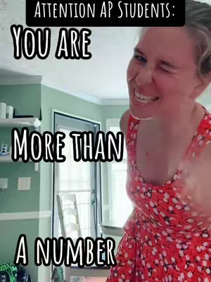 A woman in a red floral dress is shown from the chest up, slightly angled with a bright smile and a wink. Text overlays in a bold, outlined font add motivational phrases to the image. The background includes interior details like a white shelf and a door.