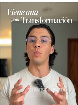 A man wearing glasses and a white t-shirt is the focal point, positioned centrally against a blurred gray background. The man has dark hair and is looking directly at the camera, as if he is speaking. Text is overlaid on the image, reading \"Viene una gran Transformación\".