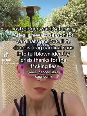 A selfie-style shot featuring a woman with light skin, wearing pink-tinted glasses and a black cap. She's positioned outdoors with a vibrant green and sunny background. Text overlays explain astrology concepts.