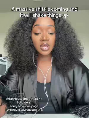 A woman with long curly hair, wearing a black robe and earbuds, is facing the camera and speaking. Text overlays at the top and bottom provide context, written in a handwritten front.