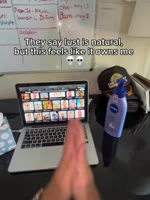 The image shows a person's hands in the foreground, with a laptop displaying multiple images in the background.  On the right are a hat and a bottle of lotion, while a whiteboard is visible behind the laptop.
