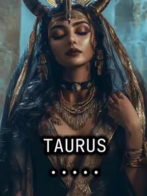 A woman with dark hair, wearing elaborate gold jewelry, a horned headpiece, and a black cape with intricate detailing. The text 'TAURUS' is overlaid in a white box over an image of what appears to be a detailed gothic or fantasy-inspired scene. Below this text, a series of dots are visible, the content suggests a visual of the Taurus zodiac.