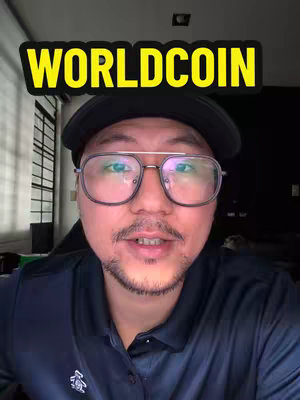 A man with glasses and a black cap looks directly at the camera. The text 'WORLDCOIN' in yellow is set on top.