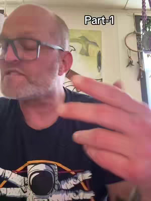 A man with a bald head, glasses, and a beard is holding up two fingers in front of a blurred background. The man is wearing a dark t-shirt with an astronaut on it. The text "Part-1" is in the top right corner.