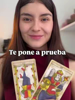 A woman smiling directly at the camera, holding two tarot cards. The main focus is on her face and the cards, with a text overlay at the bottom in large font.