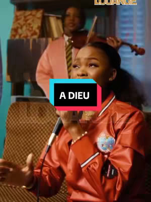A vertical video cover image featuring a young Black woman with a microphone. She wears a red bomber jacket with a patch, looking upwards with an emotional expression. Behind her, another person plays the violin, adding a musical and spiritual context. The background includes partially visible shelves and wall details. Overlayed text 'A DIEU' is prominently displayed.