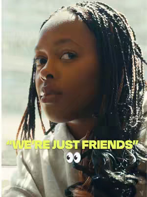 The cover image features a close-up of a young woman with braided hair. The woman is looking at the camera with a slightly questioning or observing expression. Sarcastic overlay text in yellow states "WE'RE JUST FRIENDS" with googly eyes. The background is a soft, blurred setting.
