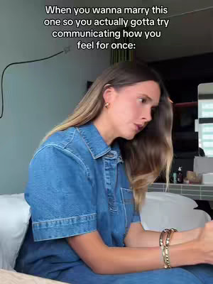 A woman in a denim shirt sits on a bed, looking thoughtful. Text overlays in the image.