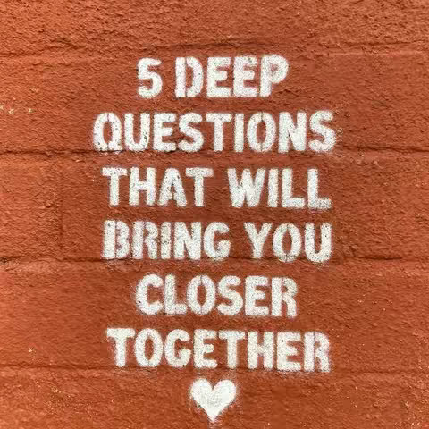 Image of a red brick wall with text overlaid. The text, in a bold, white, stencil font, reads: "5 DEEP QUESTIONS THAT WILL BRING YOU CLOSER TOGETHER". A white heart is at the bottom.