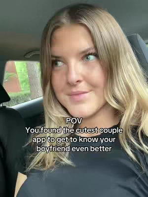 A young woman is seen inside a car in a POV shot. She is looking towards the side, her expression is gentle and dreamy. The text overlay features a callout for a couple app.