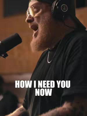 The cover image features a man in front of a microphone, singing. He wears a black t-shirt, glasses, and headphones. The text overlay says, "HOW I NEED YOU NOW."