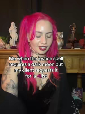 A woman with bright pink hair smiles and speaks directly to the camera. Text overlays the image in a clean white font, describing a situation related to spells. The background is dimly lit with blurred objects and a warm color palette. She is wearing a black ensemble with a necklace that highlights her chest and her open arms gesture in a relaxed manner.