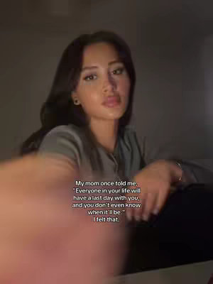 A woman with long dark hair is centered in the frame, gazing slightly to the side with a soft expression. The background is dark, with subtle lighting effects. Overlaid on the image is a series of text in a clean sans-serif font, quoting a memory of a mother's advice about the finality of relationships. The text is white and clearly readable, layered over the image to offer context to the creator's expression.