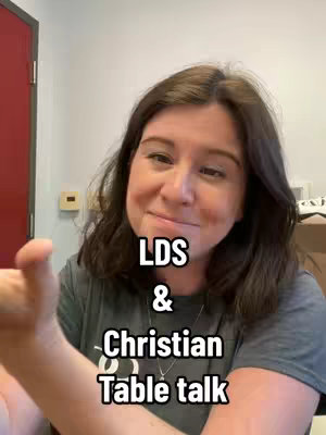 A woman with shoulder-length brown hair smiles into the camera, gesturing with her left hand. Text overlays read 'LDS & Christian Table talk'. The background is blurry, but appears to be an office or room setting.