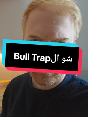 A man with light-colored hair and a beard is shown from the chest up. A rectangular text overlay partially covers his face with the words "Bull Trap" in white, along with Arabic text. The background is a blurred interior setting.