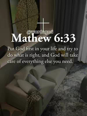 The image is a vertical shot of a modern living room interior. In the forefront is a white sofa with several pillows, and a patterned rug lies beneath it. A large abstract art piece hangs on the wall behind the sofa, and a cross icon is positioned at the top of the image. Overlayed text is present, including a bible verse and creator's handle.