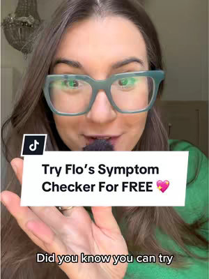 A woman with glasses holds up a phone in front of her face against a background. A graphic overlay displays the text "Try Flo's Symptom Checker For FREE" with a heart icon. The woman is smiling.
