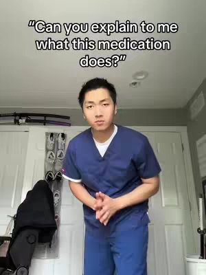 A man in a dark blue medical scrub is posed in front of a neutral background. He is positioned in the center of the frame, hands clasped in front of him. Overlay text near the top says: Can you explain to me what this medication does?.