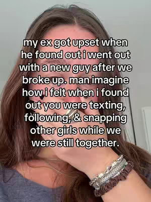 A close-up shot of a woman with brown hair partially covering her face. She is wearing a silver bracelet on her wrist and has her hand over her mouth. Text overlayed describes a situation of betrayal in a past relationship.