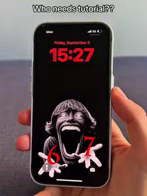 The cover image shows a smartphone displaying a scary face as a wallpaper which also displays the time and date. The background of the phone is black. The phone is being held up by a hand.
