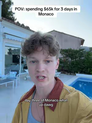 A young man is in the foreground of a video, shot from a slightly low angle. He is standing on a patio, in front of a house with white walls and glass doors. Behind him, there's a beautiful view of the water, sky, and vegetation. Text overlays on the top white bar and below the creator. The man is wearing a light blue shirt under a yellow short sleeve shirt, with some shadow on his face from the strong sunlight.