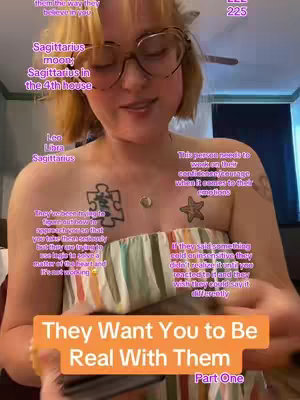A woman with blonde hair and glasses is centered in the frame, smiling slightly while looking towards the camera. Text overlays with astrological signs and phrases are scattered across the image. Her tattoos are visible.