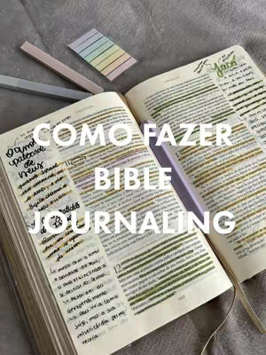 An open Bible, with highlighted text and handwritten notes, forms the centerpiece against a gray background. The overlaid text "COMO FAZER BIBLE JOURNALING" in white, large font suggests a tutorial or guide. Additional elements include a folded sticky note with color-coded sections and pens.