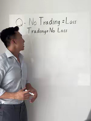 A man stands in front of a whiteboard, looking towards the left. The whiteboard has handwritten text on it, and the man is holding a marker.