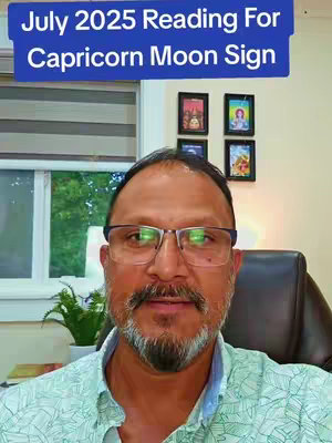 A man with glasses and short hair looks directly at the camera. Overlayed at the top is a blue bar with white text. The background includes a window with sunlight, a plant in a pot, and framed pictures.