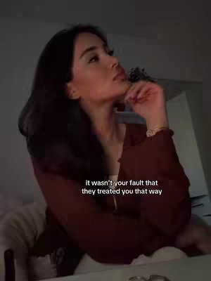 A woman with dark hair is shown in profile, looking up thoughtfully. She is wearing a dark red top. Text overlayed on the image says "it wasn't your fault that they treated you that way."