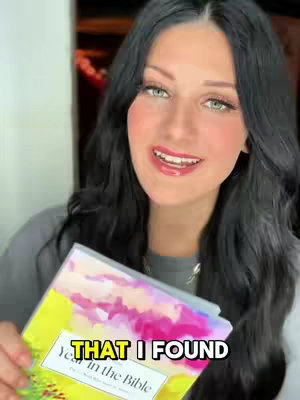 A woman with long, dark hair and green eyes smiles warmly, holding a book titled 'Year in the Bible'. The image is brightly lit, and the woman is centered, creating an inviting composition. Text is overlaid at the bottom right.