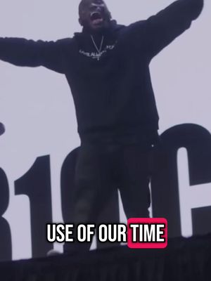 A man with his arms outstretched and mouth wide open, standing in front of a large white surface. Text overlayed on the image reads "USE OF OUR TIME".