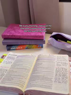 A well-lit shot of a desk with an open Bible, other books, and a pencil case. Text is overlaid that says "Me every morning - because the one who created me deserves the first part of my day."