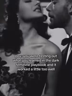 A black-and-white image showing a couple in a close embrace. The woman is on the left and is slightly out of focus, with dark hair and a dress. The man is on the right, in focus, and is whispering into her ear. Text overlayed on the image states "pov: you were testing out what you learned in the dark feminine playbook and it worked a little too well"