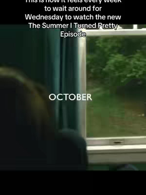 The image shows a blurred interior view of a window, with text overlays. The scene includes a portion of what seems to be a person's shoulder and back on the left. Outside the window, there's a glimpse of green foliage. The word 'OCTOBER' is prominently displayed in the center of the image with white text.