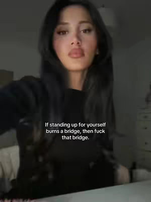 A woman in a black top poses looking directly at the camera, with text overlayed. The background is a soft, blurry interior. The lighting appears dim, and the woman has long black hair.