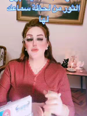 The cover image presents a woman with red hair wearing glasses, a red polka-dot shirt, and light makeup. She appears to be the focus, giving a reading, with some books or cards in front of her. At the background, an artwork, a black cat statue, a candle and a small table.