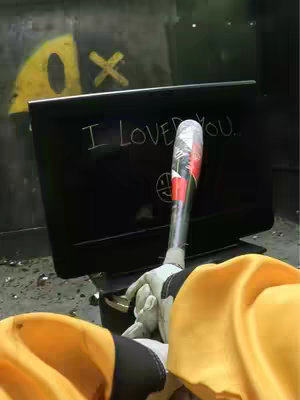 The cover image shows a person, viewed from the chest down, holding a baseball bat in front of a damaged TV. On the TV screen, the words "I LOVED YOU." are visible. The background features graffiti. The person is wearing yellow clothing and white gloves. The image has a gritty, somewhat dark aesthetic.