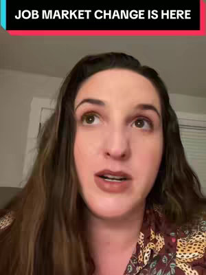 A woman with long brown hair and a patterned top looks up with a serious expression. Text over her head says 'JOB MARKET CHANGE IS HERE'. The background is a dimly lit interior.