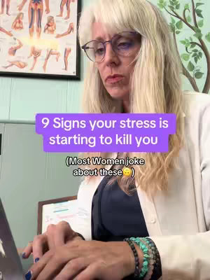 The image shows a woman with blonde hair and glasses sitting in front of a laptop. The background includes a poster with anatomical drawings and a wall with a medical theme. A text overlay asks about signs of stress.