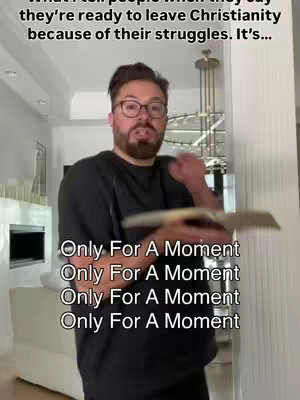 The cover image features a man in a home setting, seen from the waist up. He wears a black shirt, glasses, and has facial hair. He faces the camera with a serious expression, holding a book with both hands, gesturing with it dynamically. The text overlayed on the image has the phrase "Only For A Moment" repeated four times, vertically down the right side of the screen, set against a blurred domestic background with neutral colors.