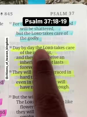 The image is a close-up of an open Bible. A dark-skinned hand with one finger extended is pointing at the highlighted text. The text "Psalm 37:18-19" is displayed in a black, rectangular box at the top. The Bible pages are marked with sticky notes.