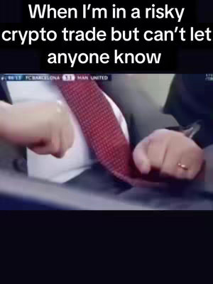 An image showing a person, with only their lower neck, hand, and part of their shoulders visible. They are wearing a white shirt, a red patterned tie covering the chest, and the person seems to be grabbing or adjusting the tie. A watch is on the wrist. The background is blurred, likely taken from a video.