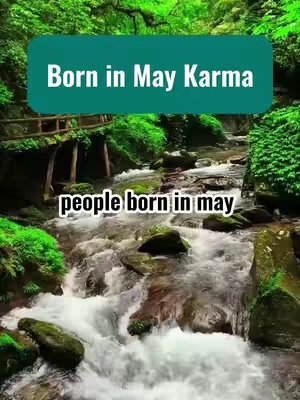 The cover image shows a serene natural setting of a flowing stream with green foliage. Overlaid are teal shapes with text. The scene includes a wooden bridge and the words: "Born in May Karma" and "people born in may."
