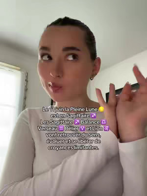 A woman is looking to the side with a playful expression, wearing a white long-sleeve top, with some text overlayed. The background shows a room with a window and a painting.
