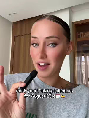 The cover image shows a woman, looking into the camera and holding a small microphone. The background is blurred but suggests a room with warm tones. Overlaid text prompts viewers to mark their calendars.
