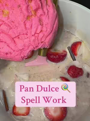 An overhead shot shows a pink mass, possibly a dessert or ice cream, partially submerged in a milky liquid. Sliced strawberries and cinnamon sticks are scattered around the pink mass. A text overlay in a pink box reads "Pan Dulce Spell Work" with a lollipop icon.